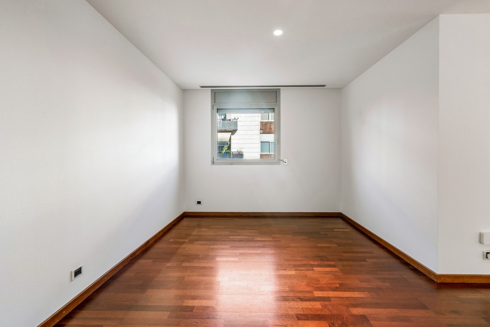 Dormitorio doble con ventana y suelo de parquet