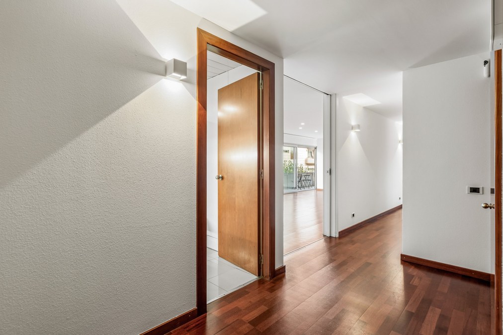 Zona de paso con suelo de parquet y acceso al salón-comedor